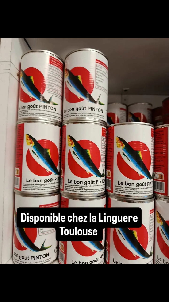 Boîtes de conserve de poisson Pinton empilées sur les rayons de l'épicerie africaine La Linguere à Toulouse, avec la mention Disponible chez la Linguere Toulouse.
