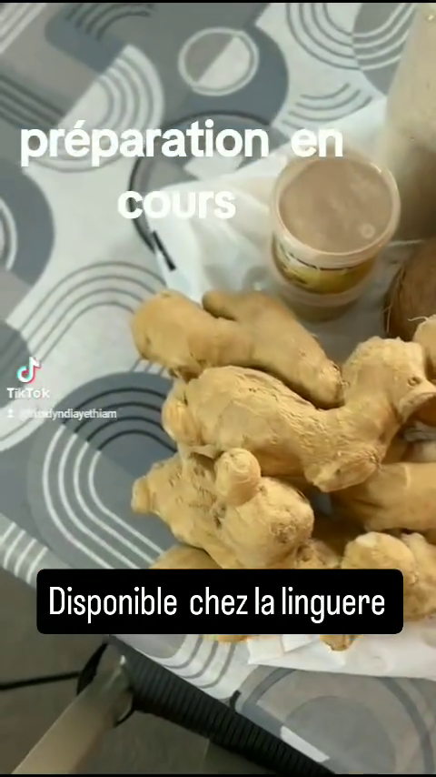Racines de gingembre frais et une noix de coco entière posées sur une table avec un petit pot, présentées comme nouveauté disponible chez l'épicerie africaine La Linguere à Toulouse.