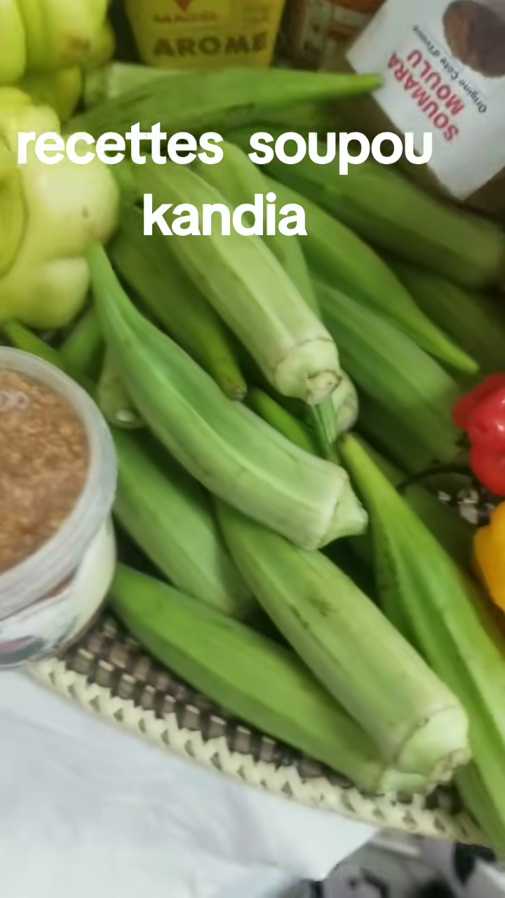 Gombos verts frais disposés près d'un bol de soumbala et de piments, ingrédients du soupou kandia.