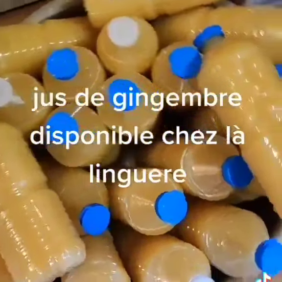 Bouteilles de jus de gingembre doré à bouchons bleus, empilées dans un carton, proposées chez La Linguere.